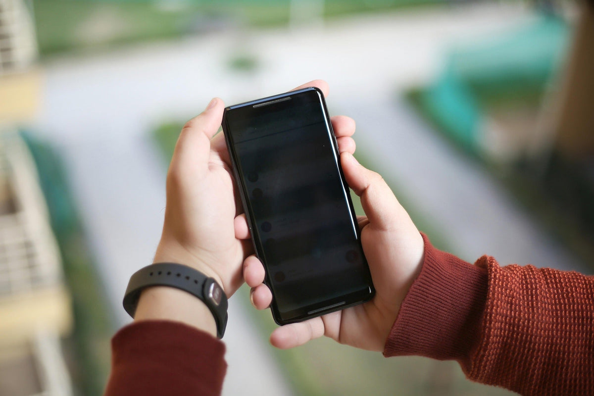 Hands holding a smartphone for a Lightroom Mobile preset installation guide
